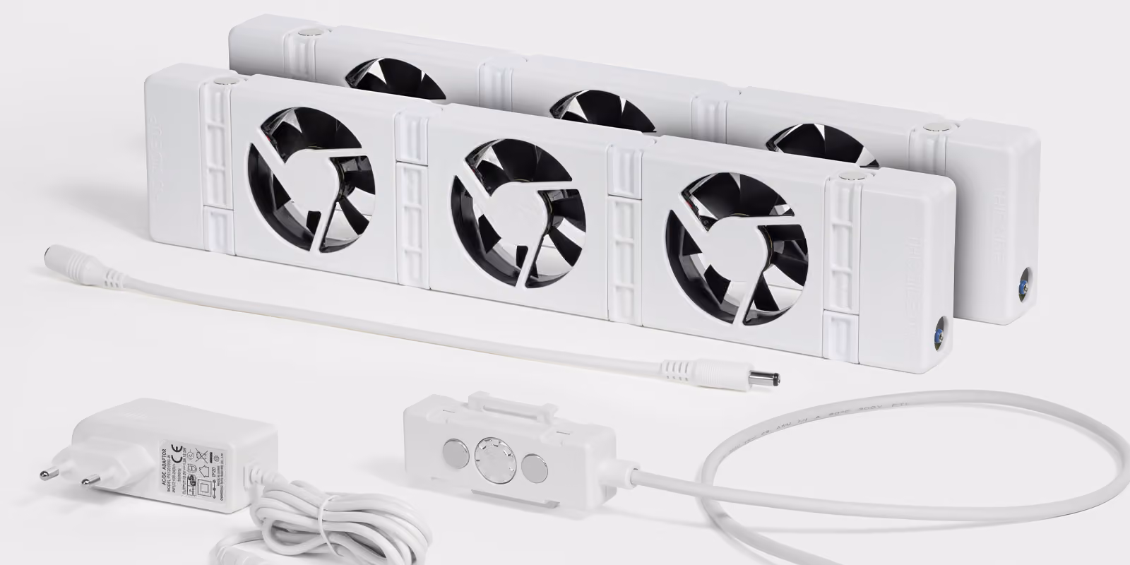 Zwei weiße Lüftereinheiten mit Steuergerät und Netzteil auf weißem Hintergrund, zur Kühlung von Elektronik.