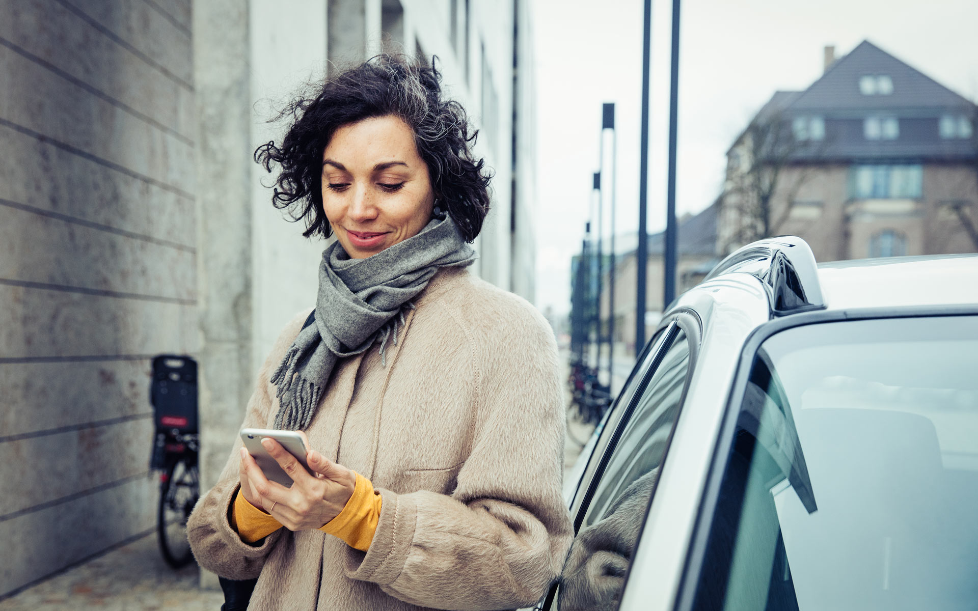 Eine Frau lädt ihr E-Auto im urbanen Raum