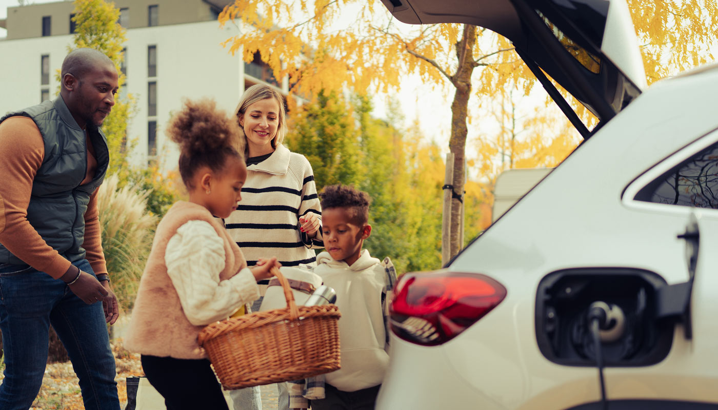 Eine junge Familie packt ihr E-Auto