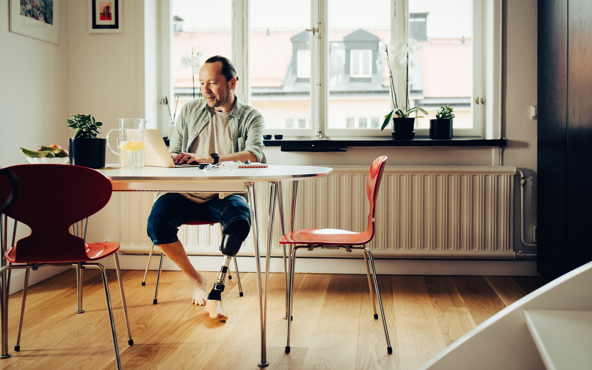 Ein Mann mit Beinprotese arbeitet am Laptop