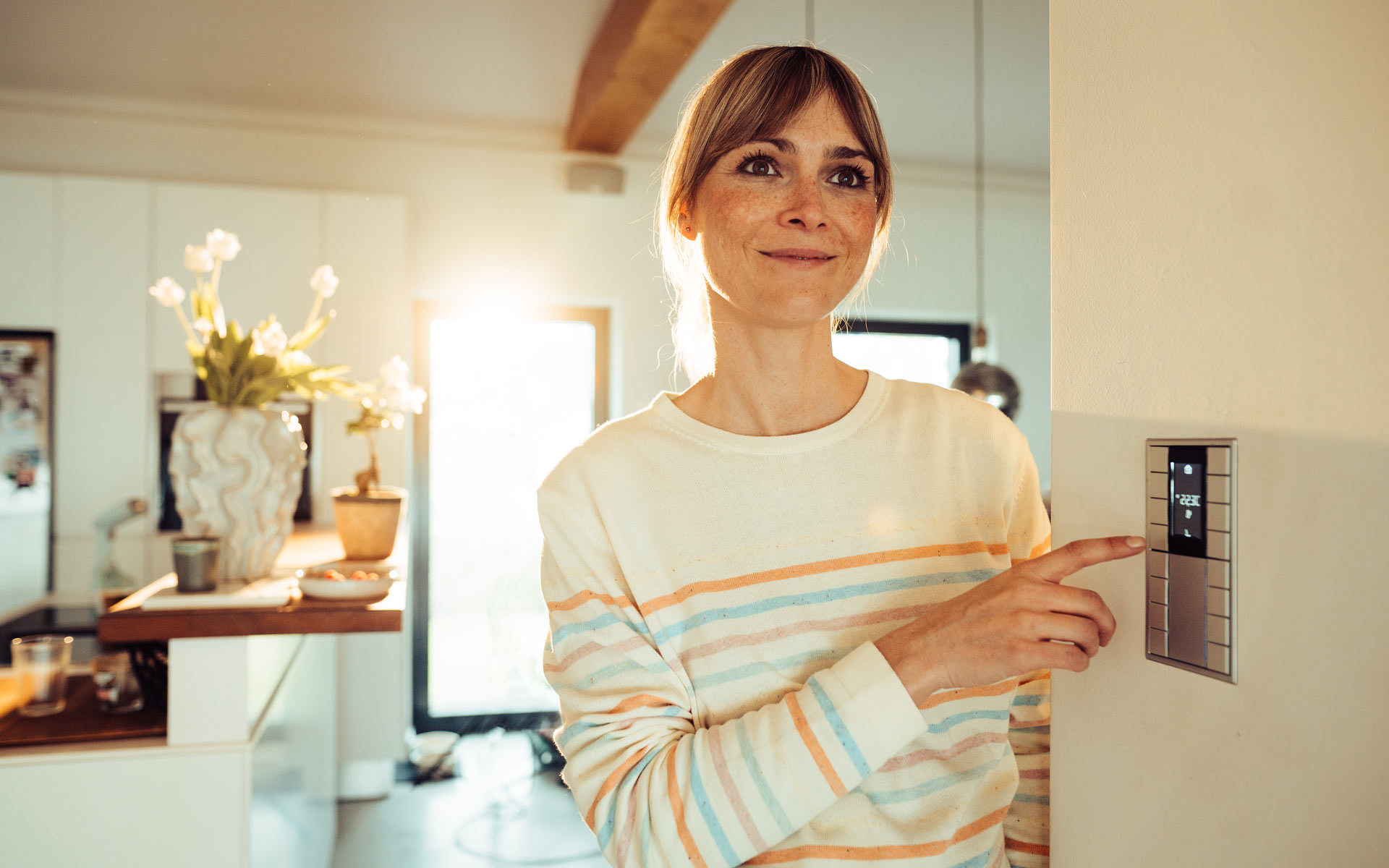 Eine Frau stellt die Temperatur in ihrem Smart Home ein.