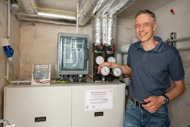 Martin Pook steht vor der neuen Fernwärmeanlage im Keller seines Mehrfamilienhauses. 