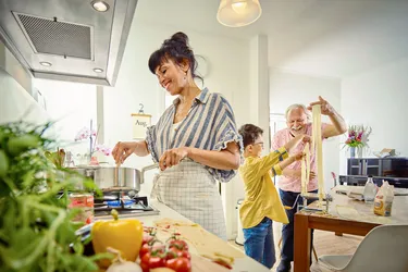 Eine Familie kocht in der Küche selbstgemachte Nudeln