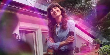 Frau vor einem Haus mit Solaranlage