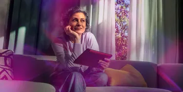 Frau auf einem Sofa mit Tablet in der Hand