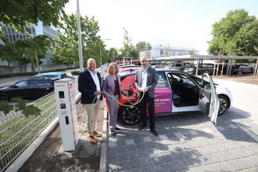 Das Bild zeigt drei Personen beim Laden eines E-Autos im Ladepark Listholze.