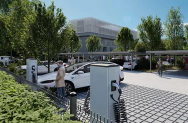 Viele Personen laden draußen im E-Ladepark ihre Autos auf.