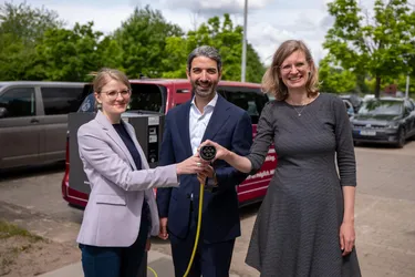 Drei Personen mit Ladestecker in den Händen 