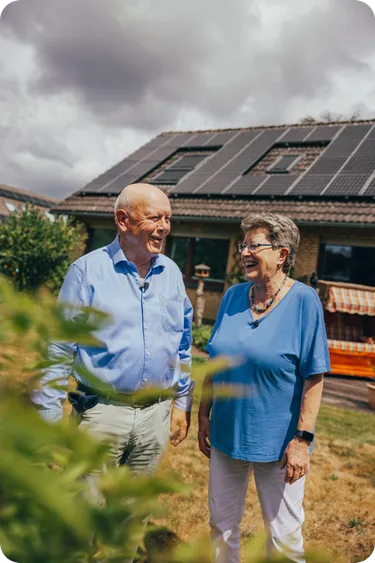 Ein Ehepaar steht im Garten ihres Hauses