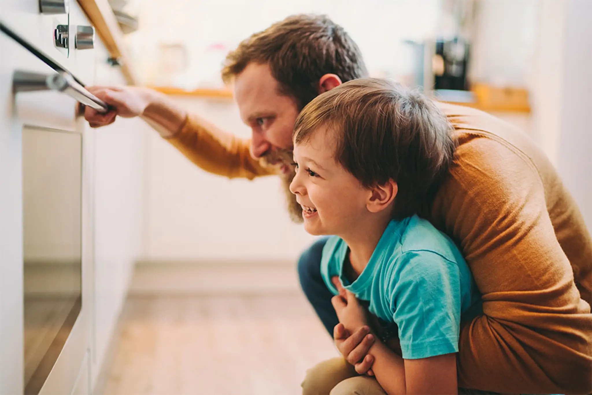 Vater und Sohn schauen in den Backofen