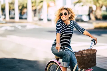 Frau auf dem Fahrrad laechelt in die Kamera