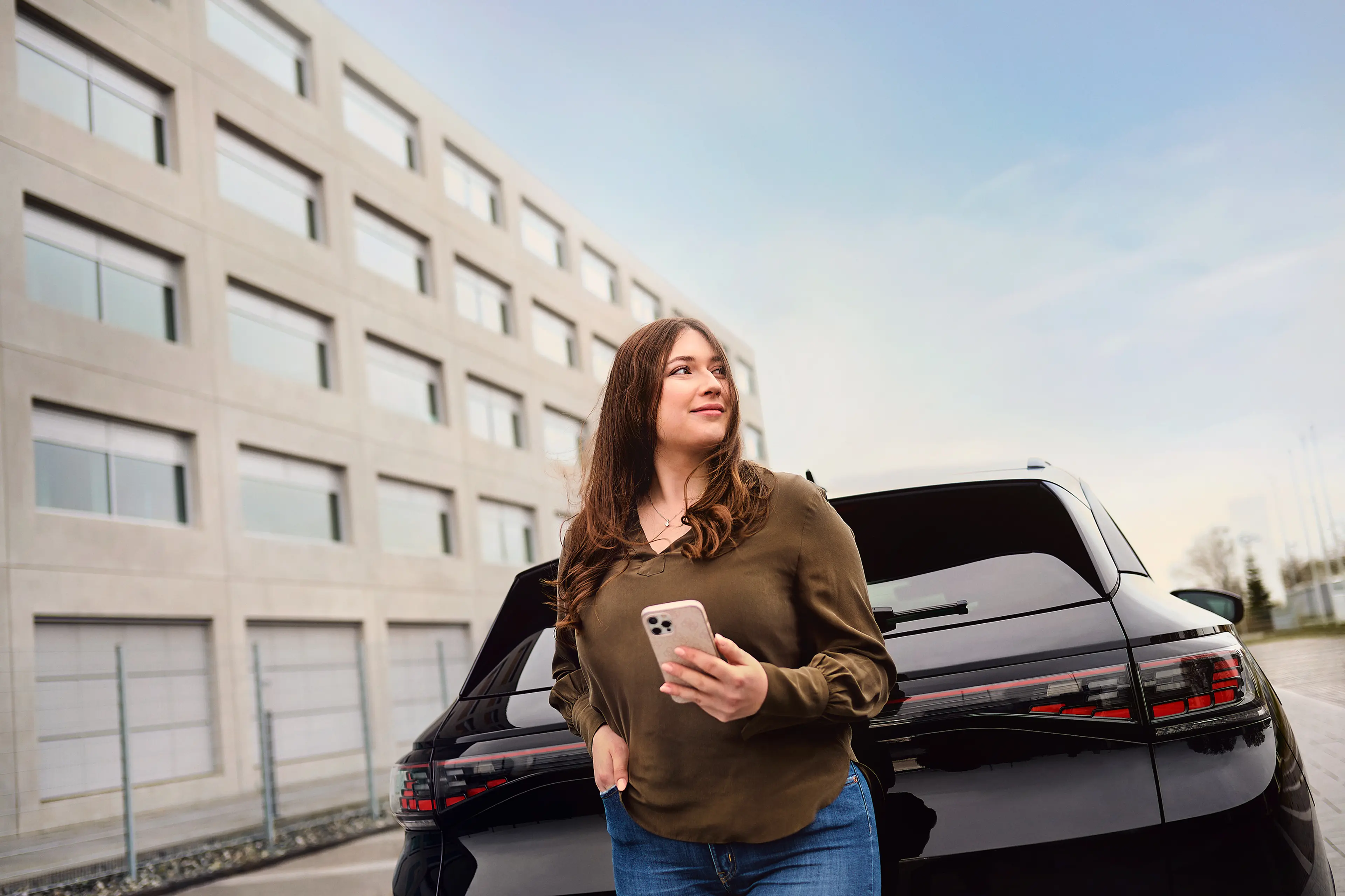 Frau mit Handy vor Auto Frau mit Handy vor Auto