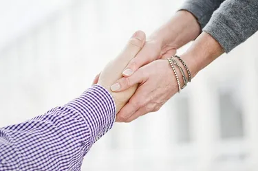 2 Hände halten eine andere Hand