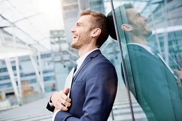 Mann lehnt sich lachend an ein Fenster