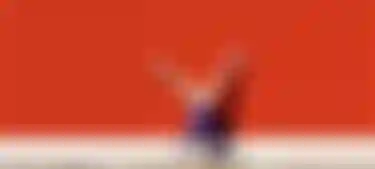 Person macht einen Handstand vor einer roten Wand