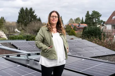 Antje Aiple steht auf dem Dach vor ihrer neuen Solaranlage.