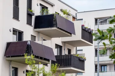 Nahaufnahme eines Wohngebäudeneubaus dessen Balkone mit Balkonkraftwerken ausgestattet sind