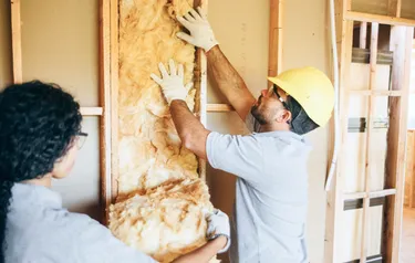 Bauarbeiter dämmen die Innenwände eines Gebäudes