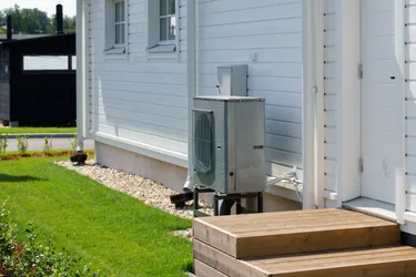 Außenmodul einer Wärmepumpe im Garten mit Abstand zum Haus