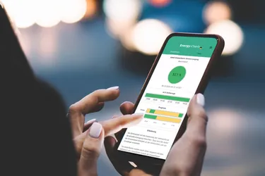 Nahaufnahme einer Frauenhand die ein Handy hält auf dessen Display die Stromampel-App des ISE zu sehen ist