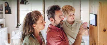 Familie stellt ein Thermostat ein