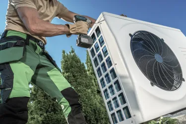 Ein Installateur installiert eine Wärmepumpe