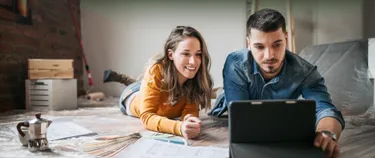 Eine Frau und ein Mann schauen auf ein Ipad