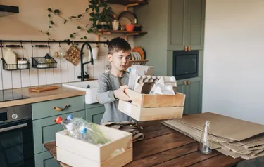 Kind sortiert Müll zum Recyclen in der Küche