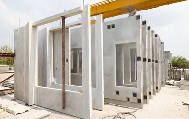 Vorgefertigte Fassadenelemente aus Beton stehen nebeneinander auf einer Baustelle