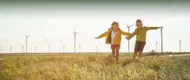 Zwei Kinder vor Windenergieanlagen