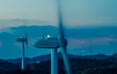 Beleuchtete Windräder in der Dämmerung