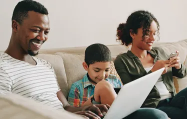 Familie sitzt gemeinsam auf dem Sofa