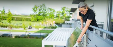 Frau montiert ein Balkonkraftwerk