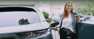 Eine Frau lädt ihr E-Auto an einer Ladestation