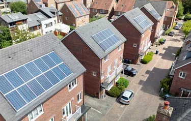 Ein Neubaugebiet mit Häusern auf denen Photovoltaikanlagen installiert sind aus der Vogelperspektive