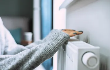 Hände über dem Heizkörper