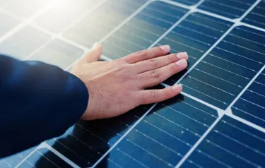 Eine Hand liegt auf einem Solarpaneel