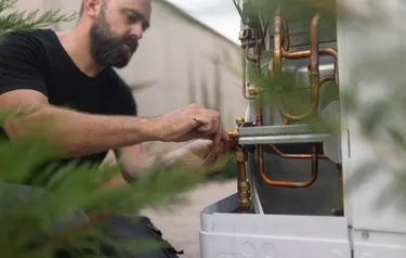 Ein Monteur führt die Wartung einer Wärmepumpe durch