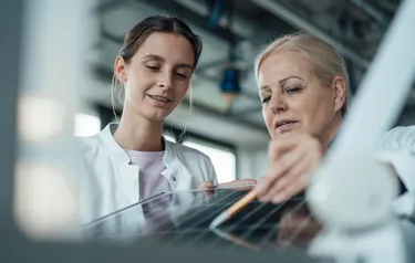 Zwei Forscherinnen betrachten ein Solarpanel