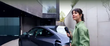 Eine Frau steht neben einem Elektroauto