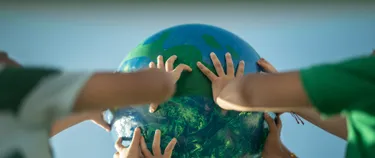 Kinde halten eine Weltkugel in den Himmel