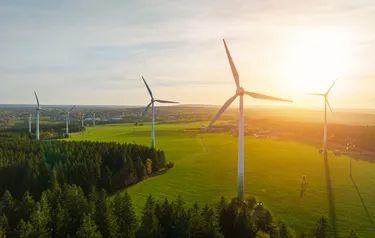 Moderne Windkraftanlagen auf einem Feld in ländlicher Umgebung