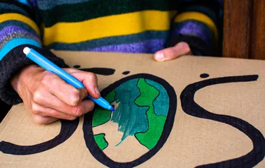 Nahaufnahme eines Mannes beim Gestalten eines Klimaschutzplakats