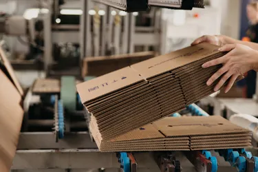 Nahaufnahme eines Pappkartonstapels auf einem Fließband