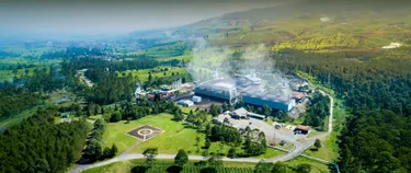 Das Bild zeigt eine Geothermie-Anlage inmitten einer ländlichen Gegend. 