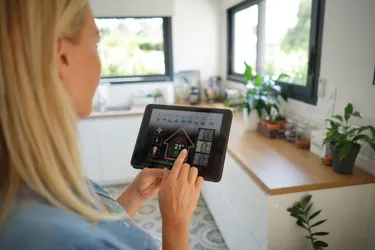 Eine Frau steht mit einem iPad im Wohnzimmer