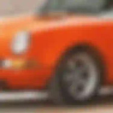 Dieses Bild zeigt einen kleinen Ausschnitt von dem vorderen Bereich eines alten, oran­ge­far­bigen Autos.