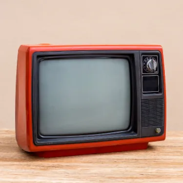 Dieses Bild zeigt einen alten Fernseher mit oran­ge­far­bigem Rahmen.