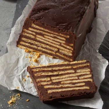 Dieses Bild zeigt die Süßspeise "Kalter Hund", die auch weitere Namen trägt. Sie besteht aus Keksen, die mit Kakaocreme bestrichen und geschichtet werden.