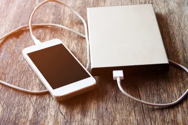 Das Bild zeigt ein Handy, welches an einer Powerbank angeschlossen ist und aufgeladen wird.